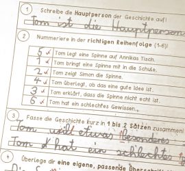 Ausschnitt einer korrigierten Deutsch-Probe: Aufgaben zu Hauptperson, Reihenfolge und Zusammenfassung, mit Schülerantworten in blauer Handschrift und roten Korrekturzeichen