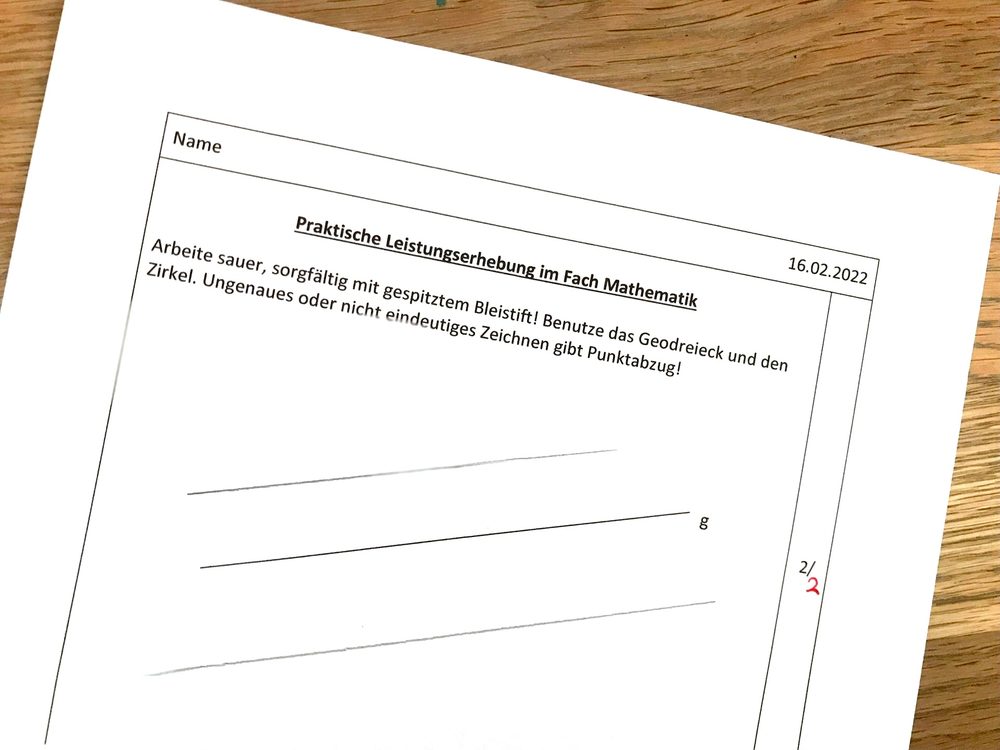 Scan einer als „Praktische Leistungserhebung im Fach Mathematik“ betitelten Geometrie-Probe vom 16.2.2022 mit schriftlicher Aufgabenstellung zum Zeichnen mit Geodreieck und Zirkel.