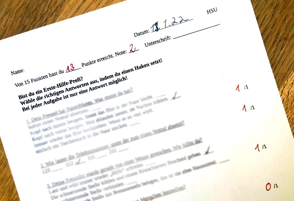 Scan eines korrigierten Multiple-Choice-Testblatts „Erste Hilfe“ im Fach HSU einer Grundschule vom 13.1.22 mit 13 von 15 Punkten und Note 2 – gewertet als mündliche Note.